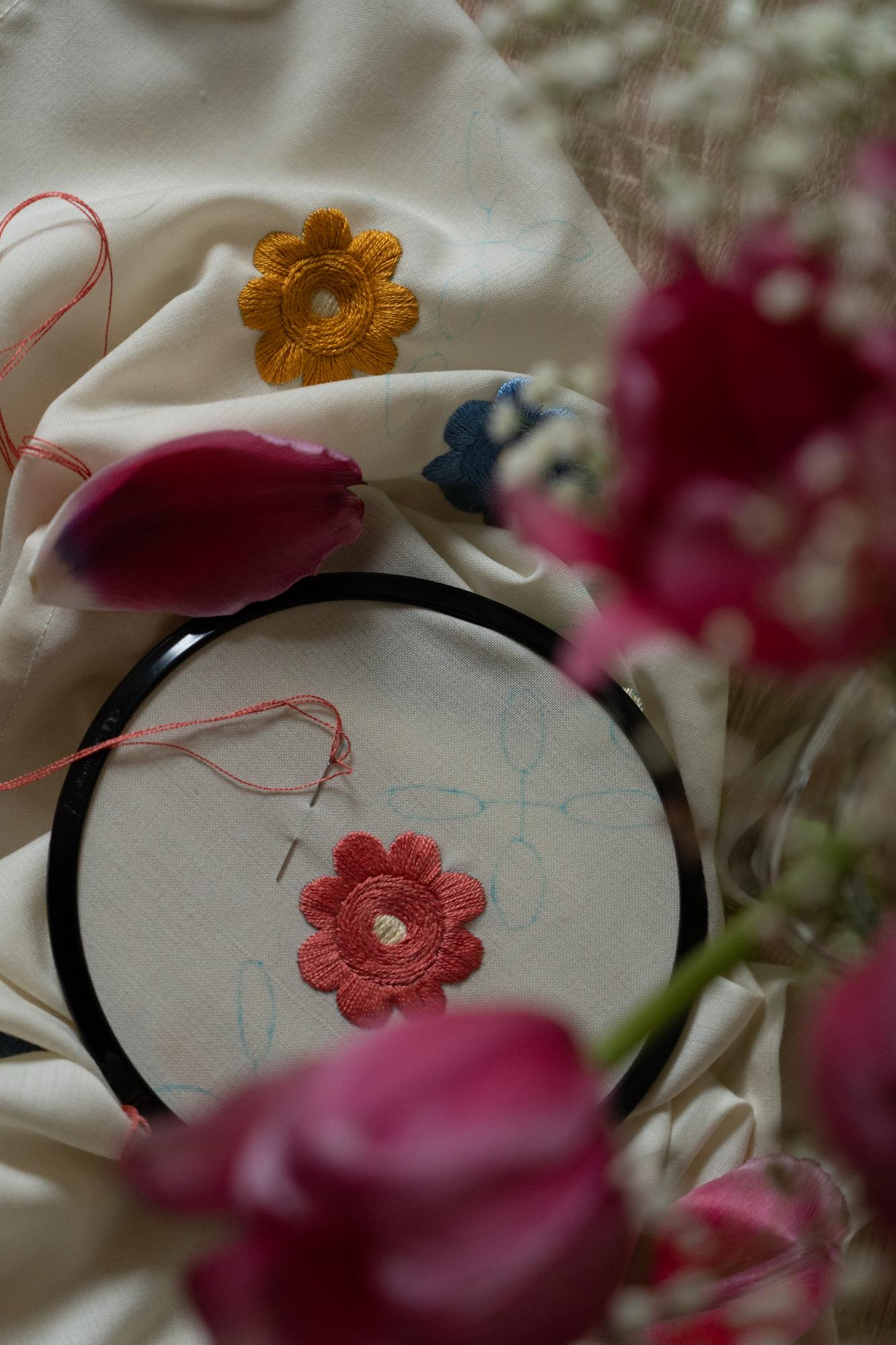 Close up of embroidered floral motif on linen
